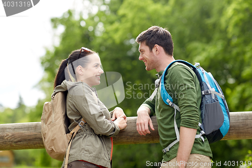 Image of smiling couple with backpacks in nature