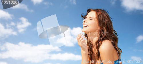 Image of happy beautiful woman over blue sky and clouds