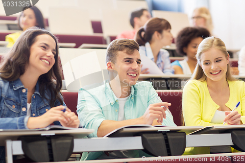 Image of group of students with notebooks in lecture hall