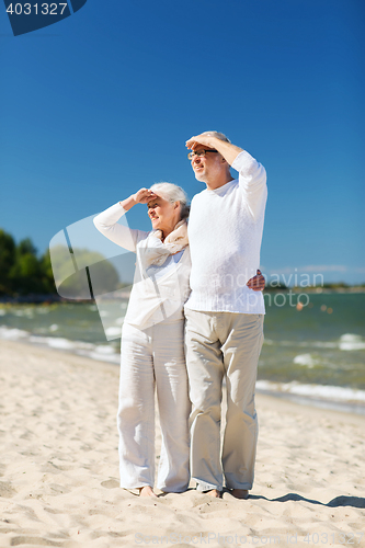 Image of happy senior couple hugging on summer beach