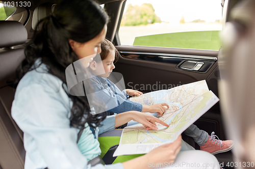 Image of happy family with travel map driving in car