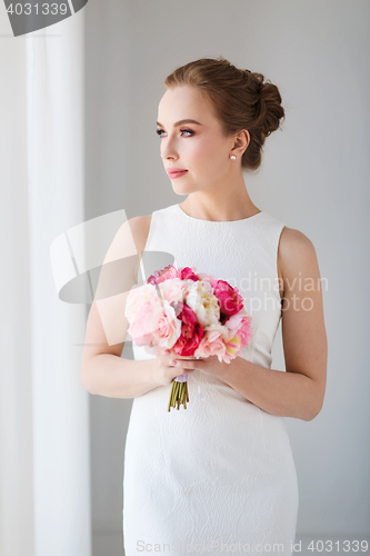 Image of bride or woman in white dress with flower bunch