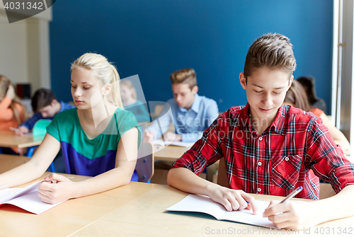 Image of group of students with books writing school test