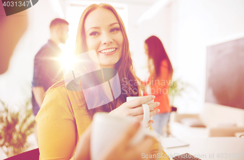 Image of happy creative team drinking coffee at office