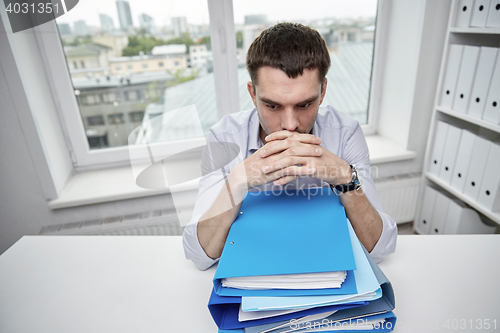 Image of businessman taking papers from secretary in office