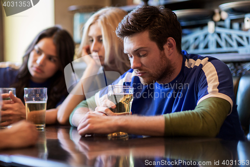 Image of football fans or friends with beer at sport bar