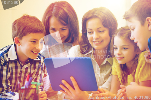 Image of group of kids with teacher and tablet pc at school