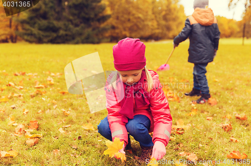 Image of children collecting leaves in autumn park