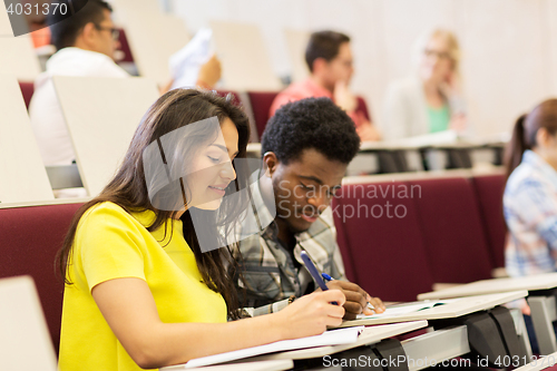Image of group of students with notebooks in lecture hall