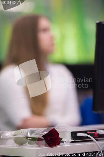 Image of rose flower on famale students table on class