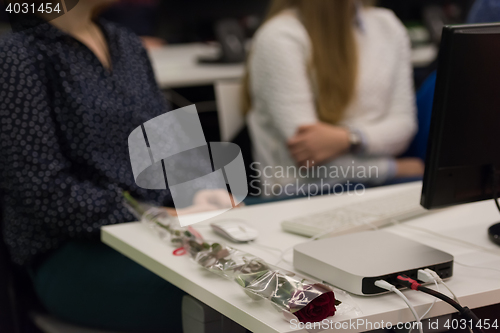 Image of rose flower on famale students table on class