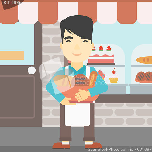 Image of Baker holding basket with bakery products.