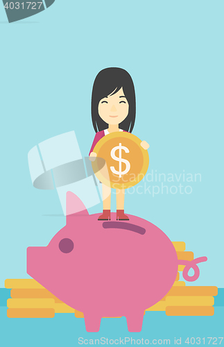 Image of Business woman putting coin in piggy bank.