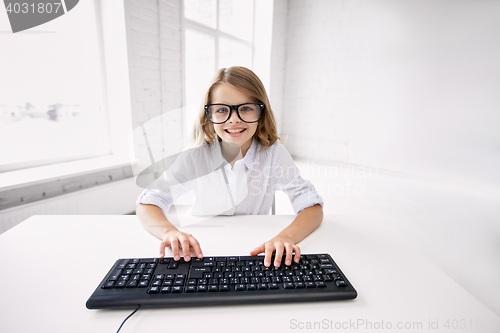 Image of smiling girl in glasses with keyboard at school