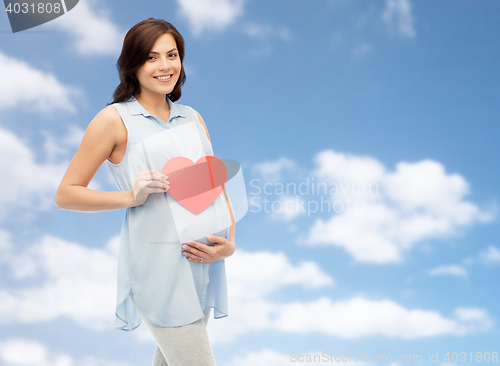 Image of happy pregnant woman with red heart touching belly