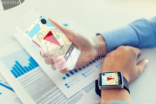 Image of hands with navigator map on smart phone and watch