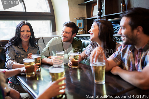 Image of happy friends drinking beer at bar or pub
