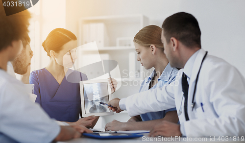 Image of group of doctors with x-ray on tablet pc at clinic