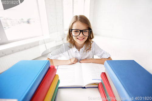 Image of happy school girl in glasses with books