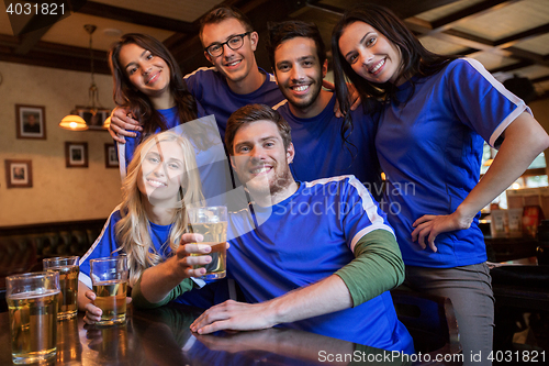 Image of football fans or friends with beer at sport bar