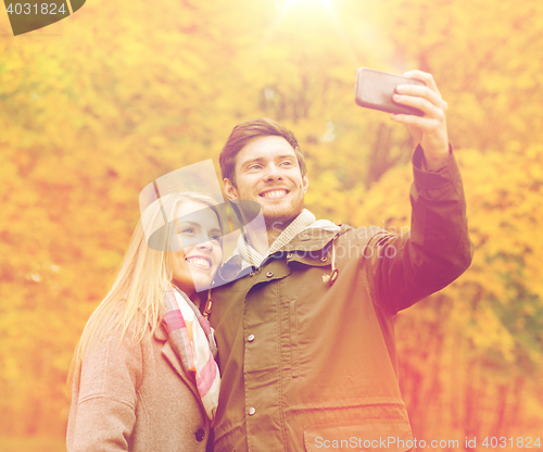 Image of smiling couple hugging in autumn park