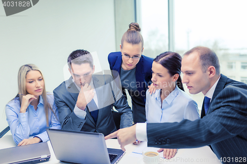 Image of business team with laptop having discussion