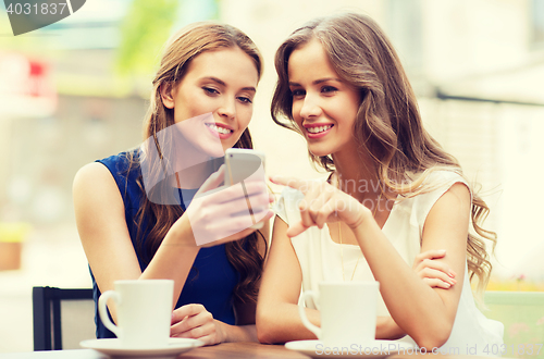 Image of young women with smartphone and coffee at cafe