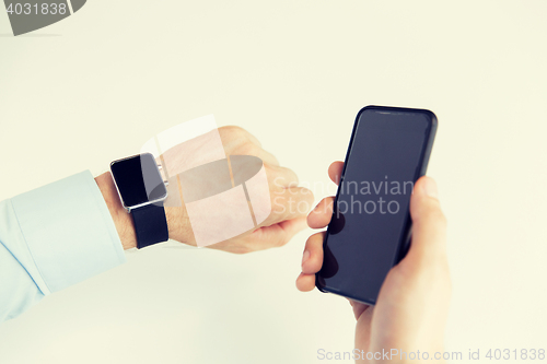 Image of close up of hands with smart phone and watch