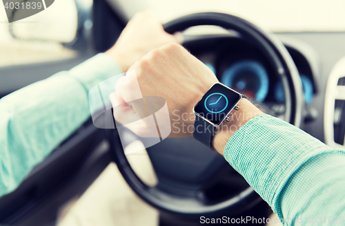 Image of close up of male hands with wristwatch driving car