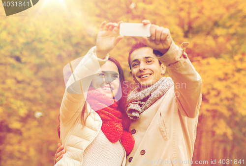 Image of smiling couple hugging in autumn park