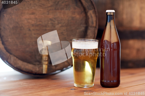 Image of close up of old beer barrel, glass and bottle
