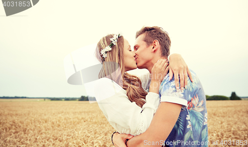 Image of happy young hippie couple kissing in field
