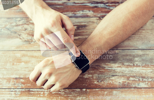 Image of close up of male hands setting smart watch