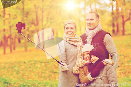 Image of happy family with smartphone and monopod in park