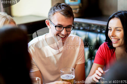 Image of happy friends drinking beer at bar or pub