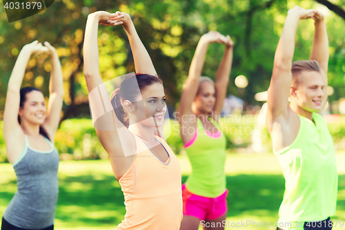 Image of group of friends or sportsmen exercising outdoors