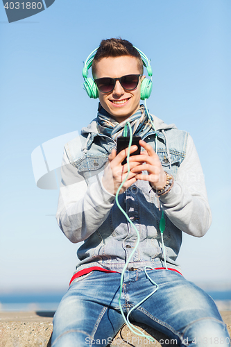 Image of happy young man in headphones with smartphone