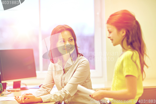 Image of school girl with notebook and teacher in classroom