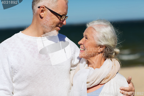 Image of happy senior couple hugging on summer beach