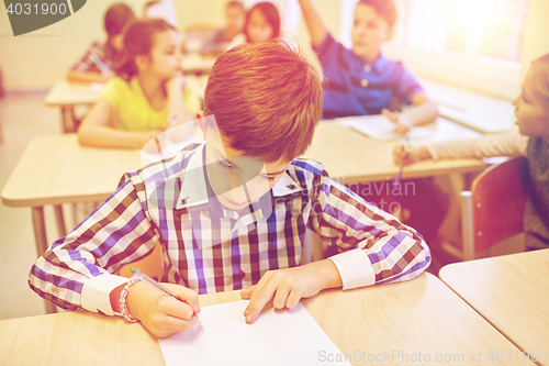 Image of group of school kids writing test in classroom