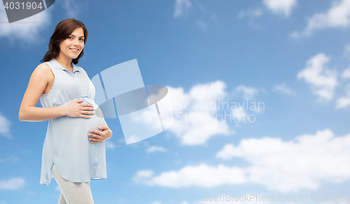 Image of happy pregnant woman touching her big belly