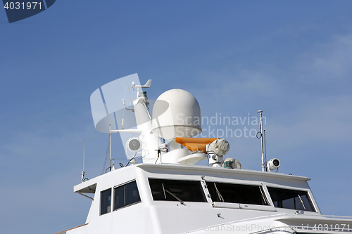 Image of Ships antenna and navigation system in a clear blue sky.