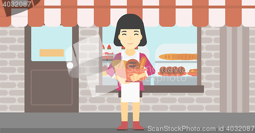 Image of Baker holding basket with bakery products.