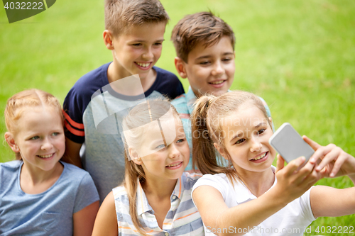 Image of happy kids or friends taking selfie in summer park