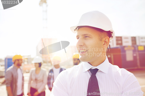 Image of group of smiling builders in hardhats outdoors