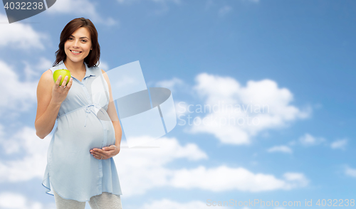 Image of happy pregnant woman holding green apple