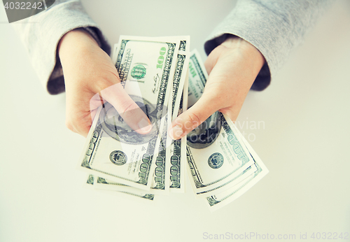 Image of close up of woman hands counting us dollar money