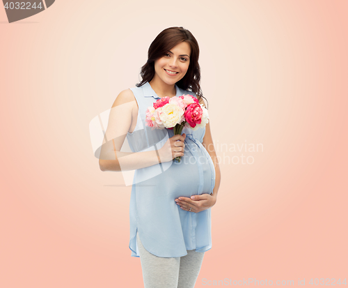 Image of happy pregnant woman with flowers touching belly