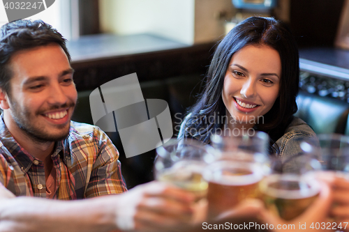 Image of happy friends drinking beer at bar or pub