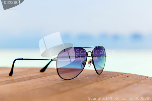 Image of shades or sunglasses on table at beach